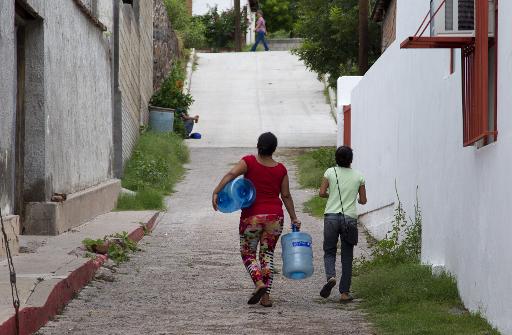 Mexicans carry empty bottles in the search for clean water