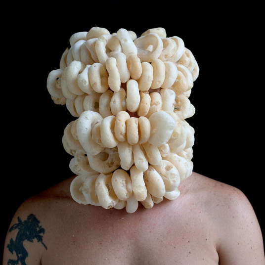 Rio de Janeiro artist Edu Monteiro surround his head with objects ranging from cigarettes and bananas to cabbage and an octopus.Credit: Edu Monteiros