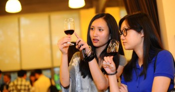 Two chinese ladies inspect fine red wine