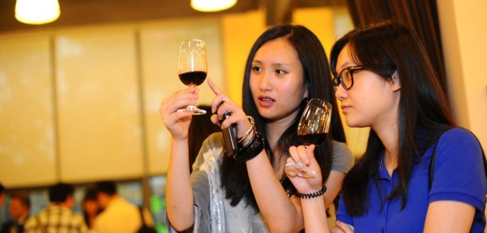 Two chinese ladies inspect fine red wine