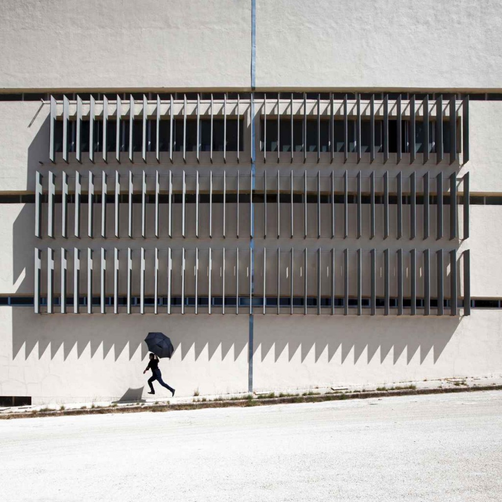 Instagram: A man running with his umbrella in the sun.