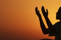 A man raises his hands to pray near the sea at sunset after a day of fasting in the holy month of Ramadan in Benghazi